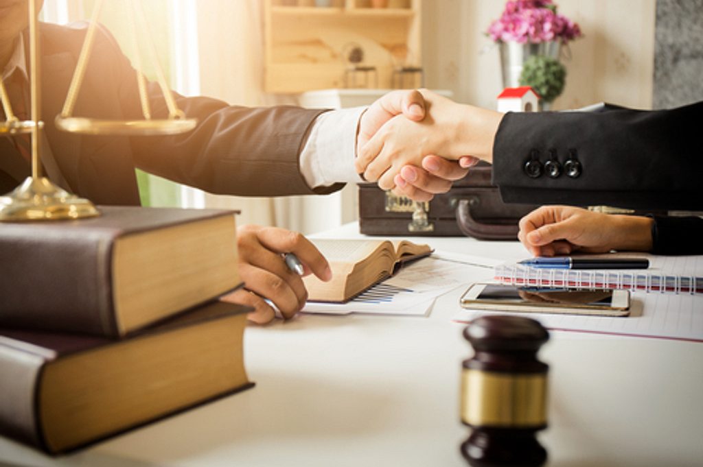 Lawyer and customer shaking hands over a desk